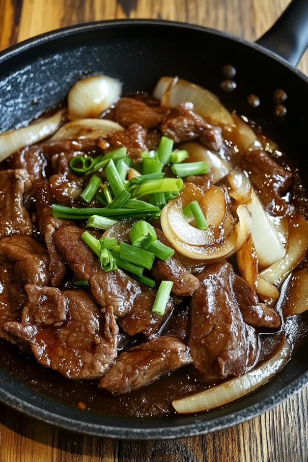 Beef and onion stir fry cooking in a pan