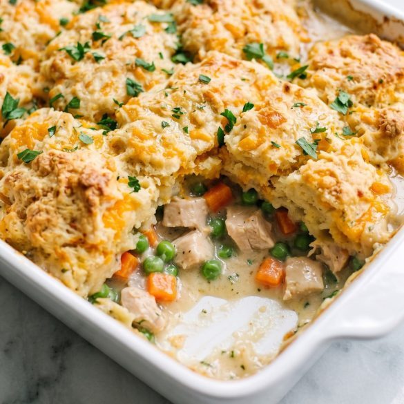 A 9x13 chicken cobbler casserole with a golden cheddar biscuit crust and creamy chicken filling