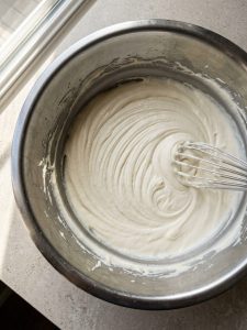 Smooth cream cheese base in a metal bowl before heavy cream is added