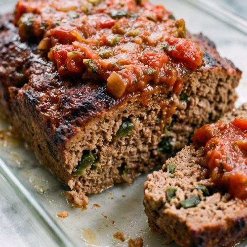 Sliced beef and chorizo meatloaf topped with chunky tomato salsa.