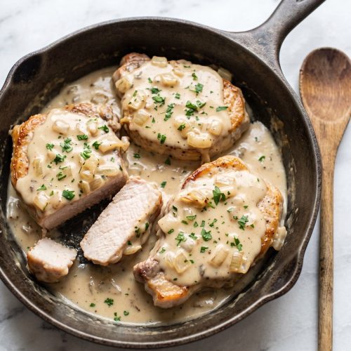 Seared pork chops, one cut open, with creamy mushroom-soup and onion gravy