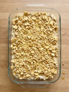 Step 5: Creamy chicken filling covered evenly with butter-coated Ritz cracker pieces before baking.
