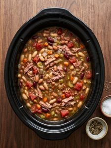Step 5: Diced tomatoes and shredded ham are mixed through the tender beans after the final 30 minutes of cooking.