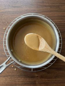 Step 7: Smooth, thickened turkey-dripping gravy coats a spoon in a saucepan.