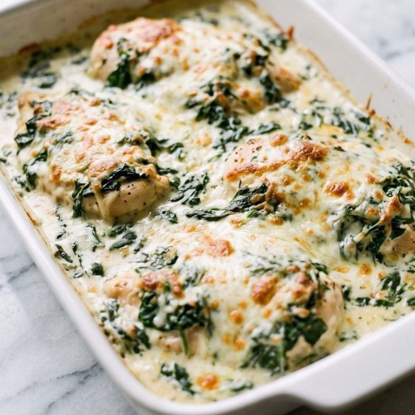 Chicken cutlets under a golden cream cheese, spinach and mozzarella topping in a baking dish