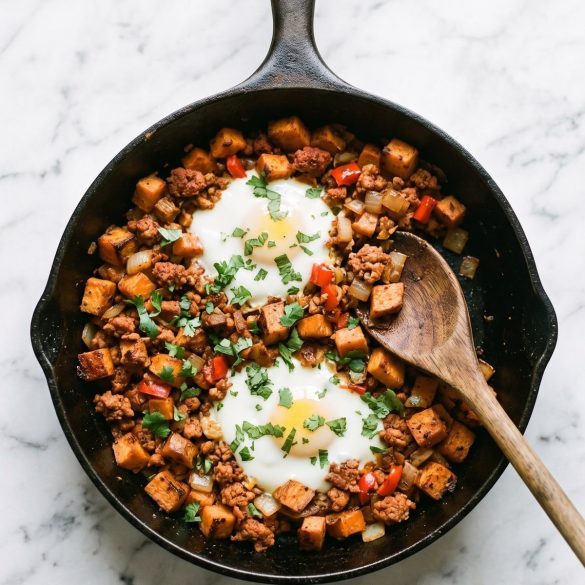 Sweet potato and chorizo hash in a cast-iron skillet with two eggs on top