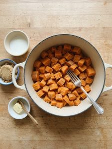 Step 2: Fork-tender sweet potato cubes sit drained in a pot, cooling before they are mashed.