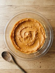 Step 3: Mashed sweet potato filling is evenly mixed in a glass bowl after the eggs have been beaten in.