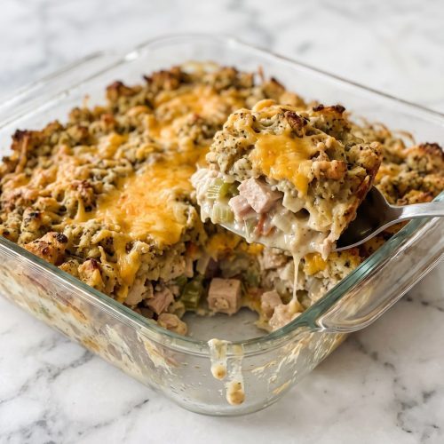 Golden stuffing topping over creamy turkey and melted cheddar in a scooped casserole