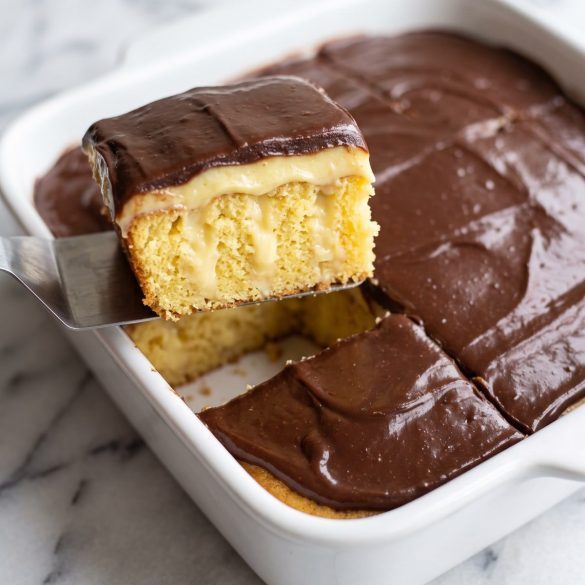 A 9x13 yellow cake with vanilla pudding and smooth chocolate frosting, one piece cut out