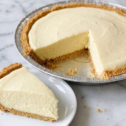 Cream cheese lemonade pie in a graham cracker crust with one slice cut out