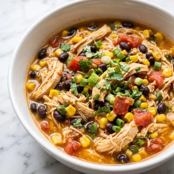 A bowl of shredded Santa Fe chicken with black beans, corn and tomatoes