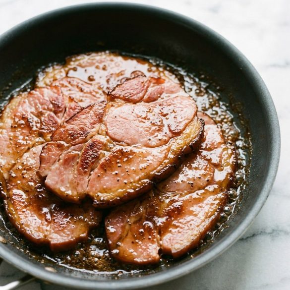 Ham steaks coated in bubbling brown sugar glaze in a nonstick skillet