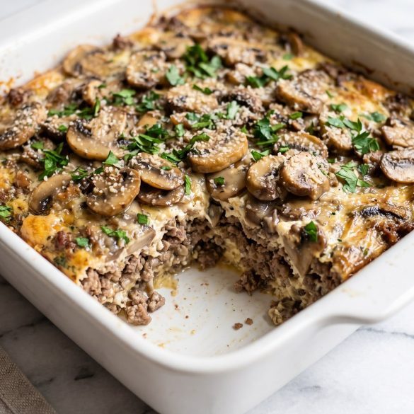 Hamburger mushroom bake in a white square baking dish with one portion scooped out