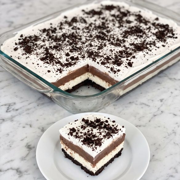 A glass dish of four-layer Oreo Delight with one square cut out