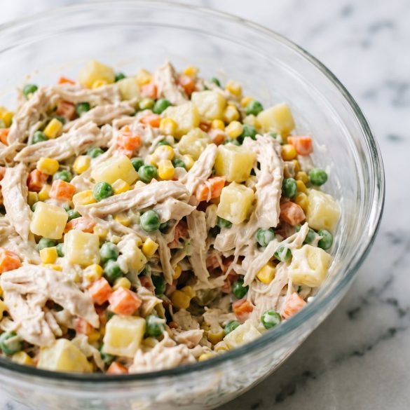 A bowl of creamy Mexican chicken salad with potatoes, carrots, peas and corn