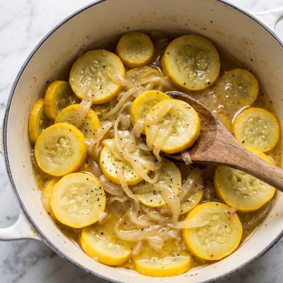 A pot of soft stewed yellow squash and onions in butter